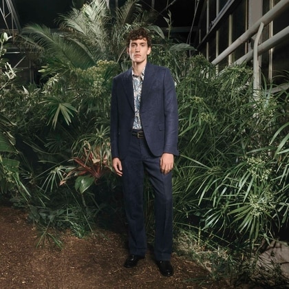 Model in a Etro suit, standing in a lush garden
