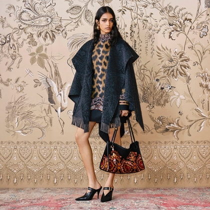 Model wearing a patterned Etro outfit with a dark fringed shawl, a printed animalier tunic and matching bag.