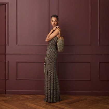 A model wearing a long dress and a golden Kalispera bag from the Etro collection