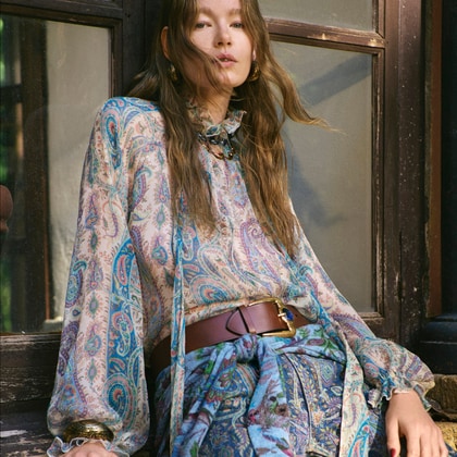 Woman wearing an Etro paisley blouse and matching trousers.