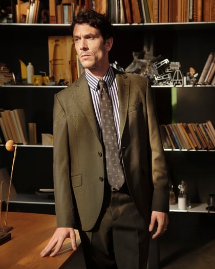 ETRO man wearing a paisley suit and striped shirt in a design studio.