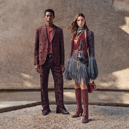 Two models wearing coordinated Etro outfits in rich burgundy and grey tones with patterned fabrics and layered accessories.