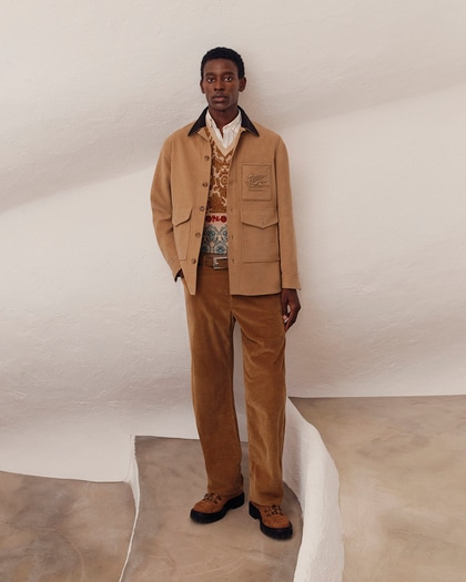 Model wearing a coordinated camel-toned Etro outfit featuring a shirt jacket with flap pockets, a patterned knit vest, and corduroy trousers, styled with rugged lace-up boots.