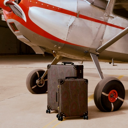 Etro x Globe-trotter luggages in front of a plane