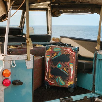 Etro x Globe-trotter luggage in a jeep in front of the sea