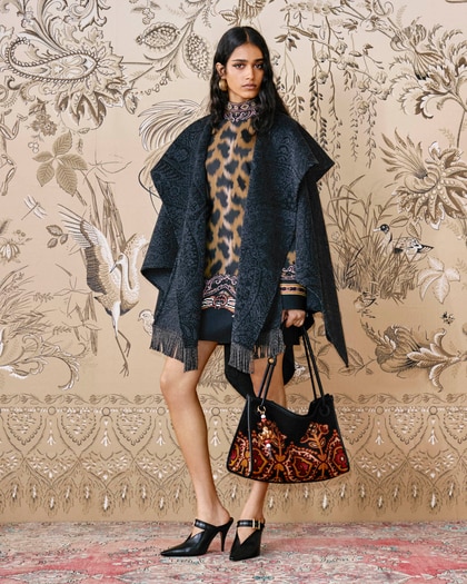 Model wearing a patterned Etro outfit with a dark fringed shawl, a printed animalier tunic and matching bag.