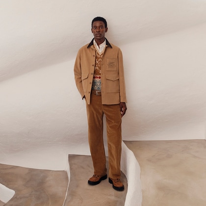 Model wearing a coordinated camel-toned Etro outfit featuring a shirt jacket with flap pockets, a patterned knit vest, and corduroy trousers, styled with rugged lace-up boots.