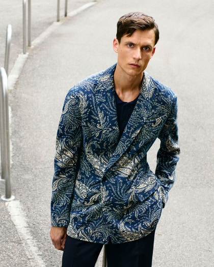 Model in a navy blue paisley-patterned Etro blazer, posing with a confident gaze.